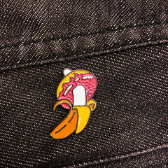 banana in a donut enamel badge on dark denim